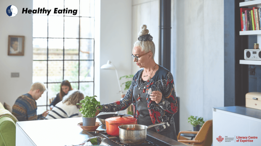 An older woman stands in a modern kitchen cooking with fresh herbs, while three people sit together at a table in the background. "Healthy Eating" is written at the top left, with logos at the bottom right.